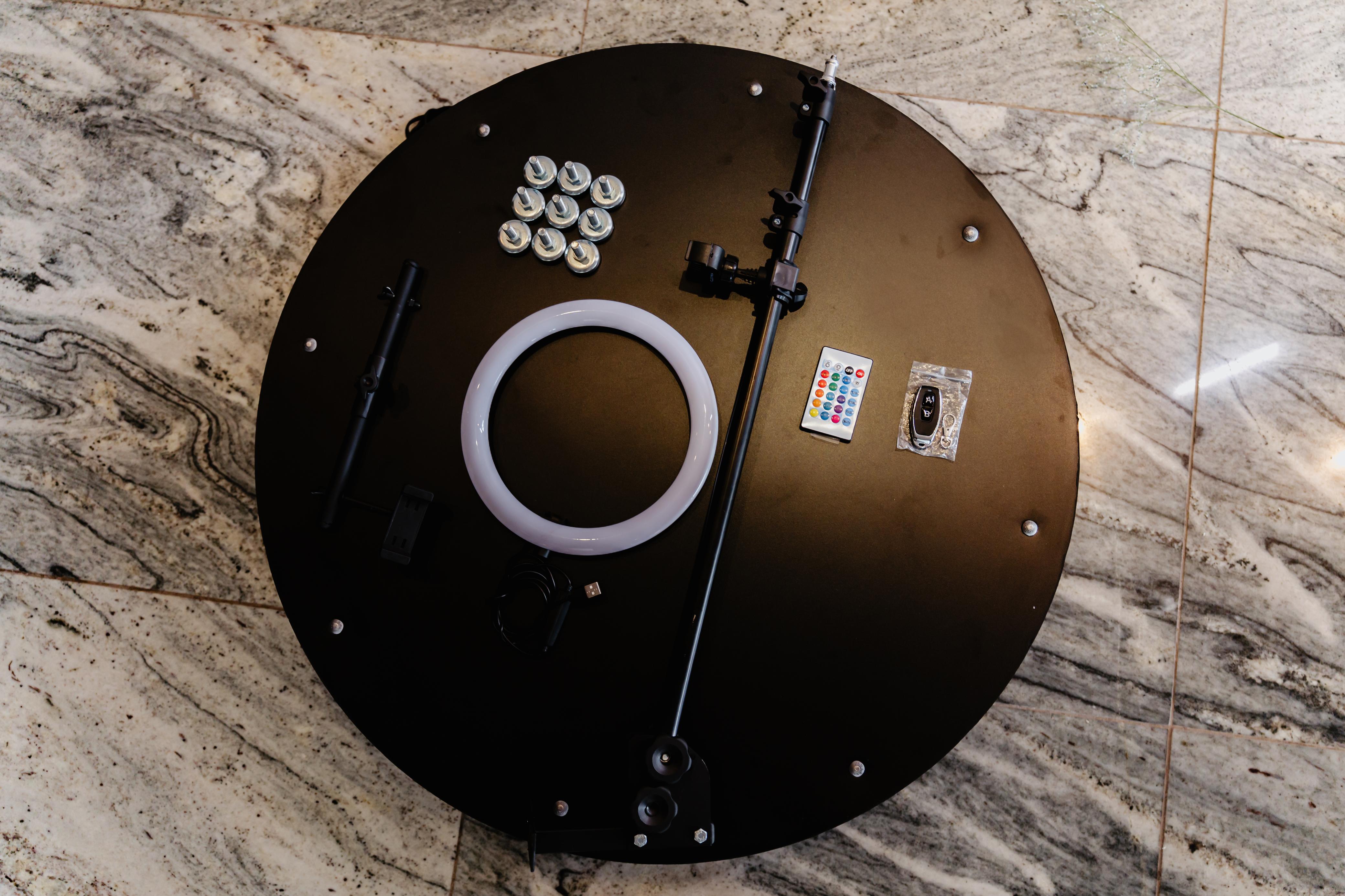 Base da Plataforma 360° com os acessórios: ring light, haste, suporte de celular, controle, power bank, cabo USB e pés niveladores