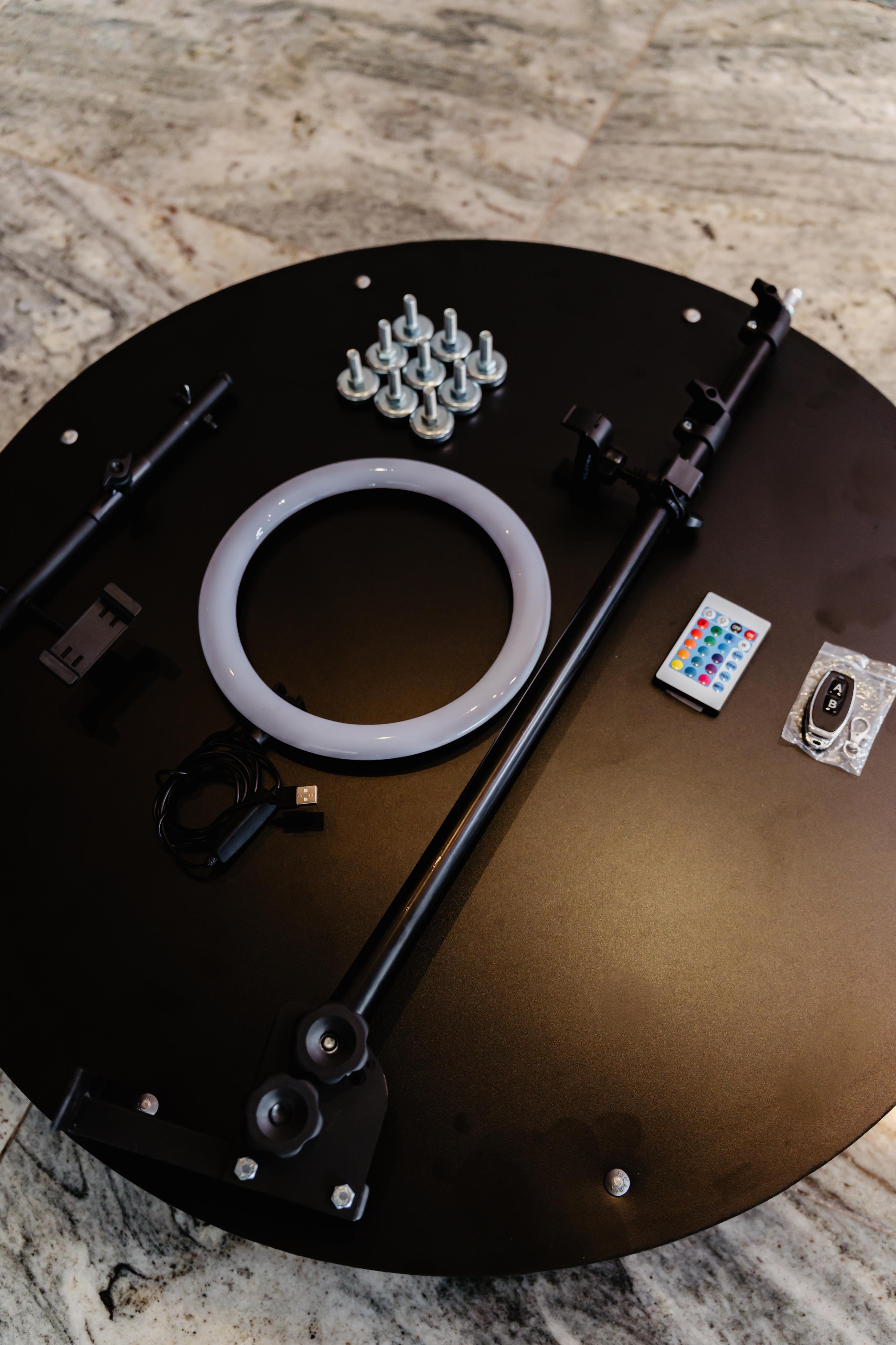 Acessórios da Plataforma 360° organizados sobre a base, com ring light, haste em alumínio, controle e pés niveladores